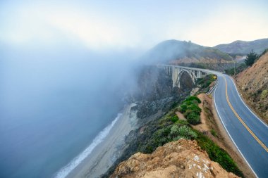 1. Otoyol ve Big Sur boyunca Pasifik Okyanusu 'nun güzel manzarası, Bixby Köprüsü' nün harika hava manzarası, gün batımı, gün doğumu, sis. Kavram, seyahat, tatil, hafta sonu.