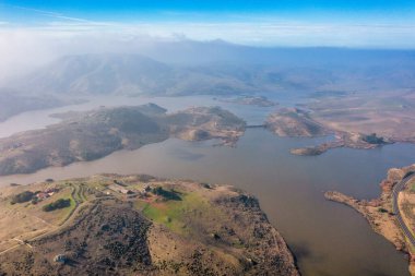 Kaliforniya 'nın yuvarlanan tepeleri ve doğal manzaralarıyla çevrili çarpıcı bir göl manzarası. Doğa meraklıları, fotoğrafçılar ve gezginler için mükemmel bir doğa harikası.