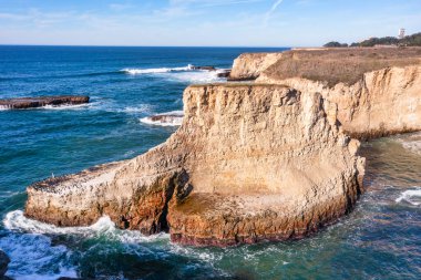 Kaliforniya 'da çarpıcı bir kıyı kaya oluşumu olan Shark Fin Koyu Pasifik Okyanusu üzerinde belirgin bir şekilde yükselir. Kayalara çarpan dalgaların olduğu pitoresk kıyı şeridi ziyaret edilmesi gereken bir yerdir.