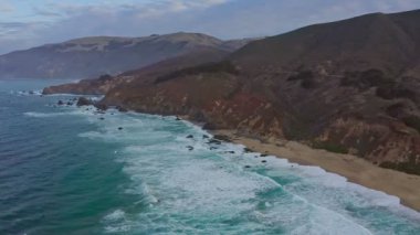 Kaliforniya 'daki 1. Otoyol boyunca Pasifik Okyanusu kıyı şeridi havadan görünüyor. Big Sur, Bixby Köprüsü, Lucia. Seyahat konsepti, turizm, seyahat, tatil. 4K video.
