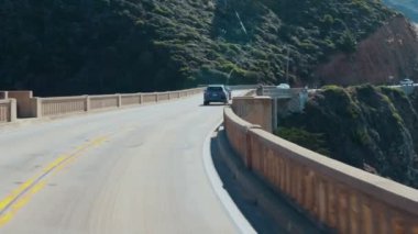 Big Sur, California, ABD - 29 Kasım 2025, Big Sur 'un 1. Pasifik Kıyısı' ndaki Bixby Köprüsü 'nde hareket halindeki bir araçtan görüntü. Dağların ve okyanusun güzel manzarası, seyahat ve tatil konsepti