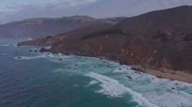 Kaliforniya 'daki 1. Otoyol boyunca Pasifik Okyanusu kıyı şeridi havadan görünüyor. Big Sur, Bixby Köprüsü, Lucia. Seyahat konsepti, turizm, seyahat, tatil. 4K video.