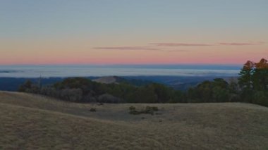 Şafakta yemyeşil bir dağ manzarasına hayret verici bir hava manzarası, çarpıcı 4K kalite bir dron tarafından ele geçirildi. Sakin vadiler ve yüksek tepeler sinematik bir doğal video sahnesi yaratır.