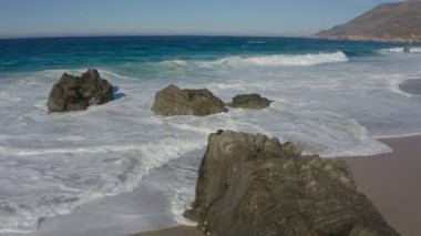 Kaliforniya 'da Pasifik Okyanusu kıyısında güneşli bir günde sahili ve dalgaları görmek. Kavram, eğlence ve seyahat