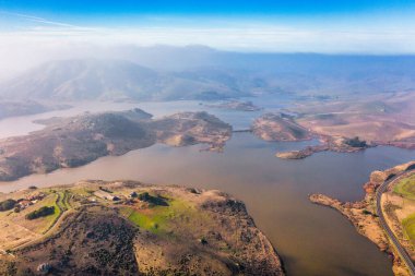 Kaliforniya 'nın yuvarlanan tepeleri ve doğal manzaralarıyla çevrili çarpıcı bir göl manzarası. Doğa meraklıları, fotoğrafçılar ve gezginler için mükemmel bir doğa harikası.