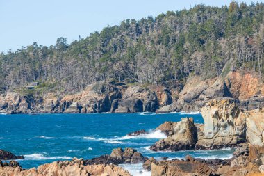 Kaliforniya 'nın Kuzey Kaliforniya Otoyolu boyunca uzanan sahil kayalıkları. Engebeli okyanus kayaları, çarpan dalgalar ve renkli bir gökyüzü nefes kesici bir Pasifik Sahili manzarası yaratır..