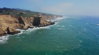 Davenport, Kaliforniya 'da 1. karayolu yakınlarındaki renkli uçurumlar ve turkuaz okyanus manzarası. Güneşli bir günde Pasifik Sahil Otobanı boyunca nefes kesici kıyı manzarası