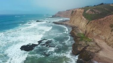 Davenport, Kaliforniya 'da 1. karayolu yakınlarındaki renkli uçurumlar ve turkuaz okyanus manzarası. Güneşli bir günde Pasifik Sahil Otobanı boyunca nefes kesici kıyı manzarası