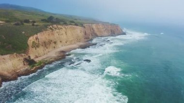 Davenport, Kaliforniya 'da 1. karayolu yakınlarındaki renkli uçurumlar ve turkuaz okyanus manzarası. Güneşli bir günde Pasifik Sahil Otobanı boyunca nefes kesici kıyı manzarası