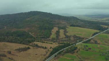 Yuvarlanan tepeler ve kırsal tarım arazileri, orman arazileri ve bulutlu bir günde dolambaçlı yollar. Doğu Avrupa 'nın huzurlu kırsal manzarası, doğa ve seyahat temaları için ideal