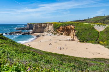 California 'daki Panther Sahili' nde turkuaz dalgalar, altın kum ve dramatik uçurumlar var. Açık bir bahar gününde yukarıdan görüldü.