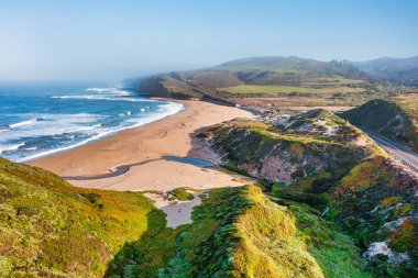 Scott Creek Sahili ve California Otoyolu 'nun havadan görüntüsü. Sahil kayalıkları, dalgalar ve dalgalar Davenport yakınlarında açık mavi gökyüzünün altında altın kumlarla buluşur.