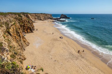 California 'daki Panther Sahili' nde turkuaz dalgalar, altın kum ve dramatik uçurumlar var. Açık bir bahar gününde yukarıdan görüldü.