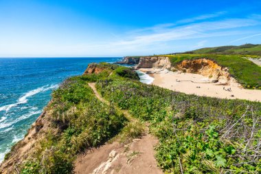 California 'daki Panther Sahili' nde turkuaz dalgalar, altın kum ve dramatik uçurumlar var. Açık bir bahar gününde yukarıdan görüldü.