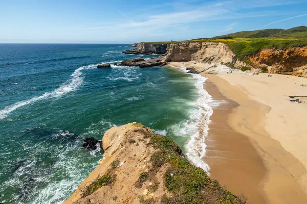 California 'daki Panther Sahili' nde turkuaz dalgalar, altın kum ve dramatik uçurumlar var. Açık bir bahar gününde yukarıdan görüldü.