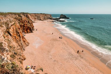 California 'daki Panther Sahili' nde turkuaz dalgalar, altın kum ve dramatik uçurumlar var. Açık bir bahar gününde yukarıdan görüldü.