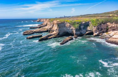 Cotoni-Coast Mandıra Eyalet Plajları 'ndaki Panther Plajı, Kaliforniya. Altın kum, dramatik uçurumlar, turkuaz dalgalar ve 1. Otoyol 'un yanındaki parlak mavi gökyüzünün altındaki manzaralı kıyı şeridi.