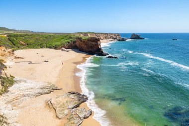 California 'daki Panther Sahili' nde turkuaz dalgalar, altın kum ve dramatik uçurumlar var. Açık bir bahar gününde yukarıdan görüldü.