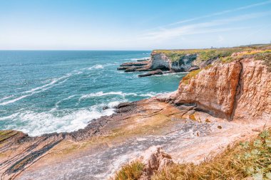 California 'daki Panther Sahili' nde turkuaz dalgalar, altın kum ve dramatik uçurumlar var. Açık bir bahar gününde yukarıdan görüldü.