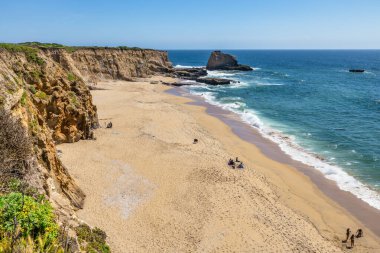 California 'daki Panther Sahili' nde turkuaz dalgalar, altın kum ve dramatik uçurumlar var. Açık bir bahar gününde yukarıdan görüldü.