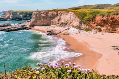 California 'daki Panther Sahili' nde turkuaz dalgalar, altın kum ve dramatik uçurumlar var. Açık bir bahar gününde yukarıdan görüldü.