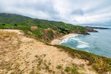 Dramatik okyanus kayalıkları ve bereketli sahil tepeleri. Devils Bunker manzaralı, Gray Whale Cove State Beach yakınlarında California manzaralı 1..