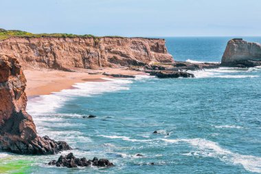California 'daki Panther Sahili' nde turkuaz dalgalar, altın kum ve dramatik uçurumlar var. Açık bir bahar gününde yukarıdan görüldü.