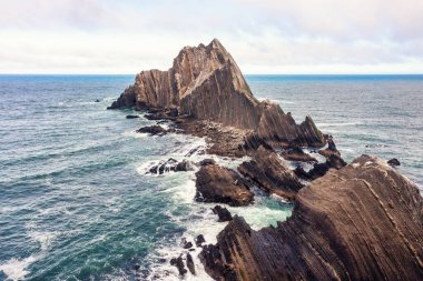 Pacifica yakınlarındaki California sahilindeki San Pedro Kayası 'nın havadan görüntüsü. Pasifik Okyanusu 'ndan keskin çizgili uçurumlar, engebeli dokular, deniz kuşları ve sisli atmosfer vahşi bir sahil manzarası yaratır.