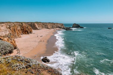 California 'daki Panther Sahili' nde turkuaz dalgalar, altın kum ve dramatik uçurumlar var. Açık bir bahar gününde yukarıdan görüldü.