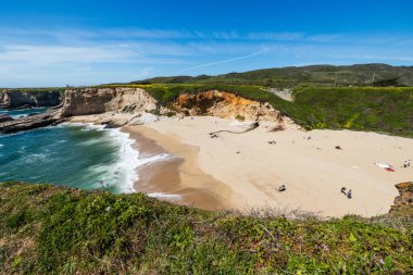 California 'daki Panther Sahili' nde turkuaz dalgalar, altın kum ve dramatik uçurumlar var. Açık bir bahar gününde yukarıdan görüldü.
