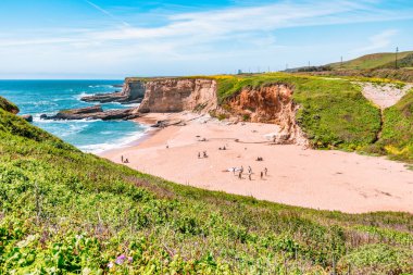 California 'daki Panther Sahili' nde turkuaz dalgalar, altın kum ve dramatik uçurumlar var. Açık bir bahar gününde yukarıdan görüldü.