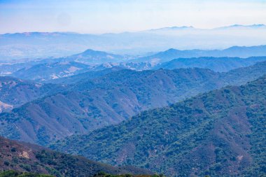 Layered mountain ridges seen from Sierra Azul Preserve near Mount Umunhum, California, USA. Forested hills fade into atmospheric haze, creating a scenic panoramic view of the Santa Cruz Mountains
