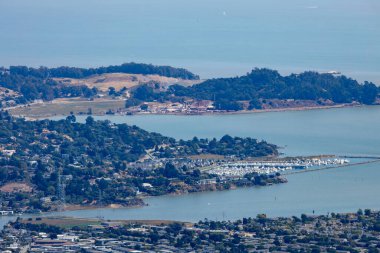 Panoramic view from Mount Tamalpais East Peak overlooking San Francisco Bay, Richmond San Rafael Bridge, Angel Island, and rolling hills of Marin County under fog and blue sky, California USA