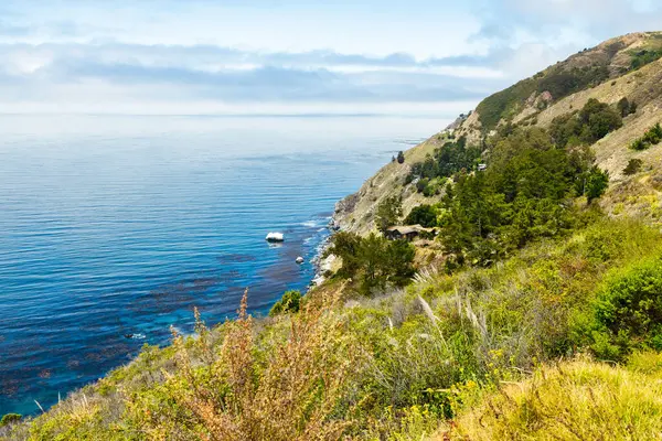 Rocky cliffs and turquoise waters along the Pacific Ocean in Big Sur, California USA. Scenic coastal landscape with dramatic shoreline, rugged rocks, and natural beauty of Highway 1 coast
