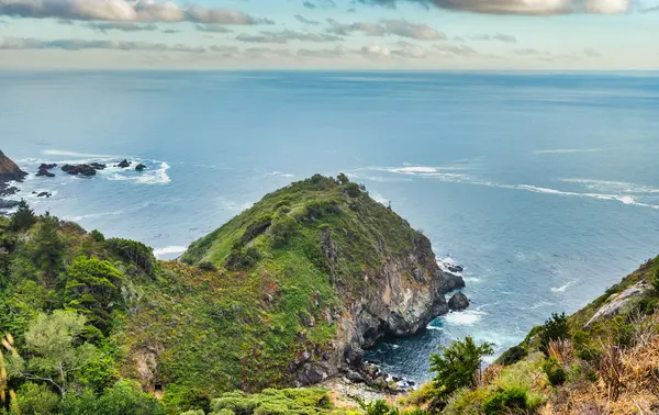 Scenic view of Partington Cove in Big Sur, California. Rugged cliffs, lush greenery, and the Pacific Ocean create a dramatic coastal landscape, a popular hiking and travel destination along Highway 1