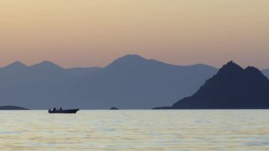Küçük tekne gün batımından sonra rıhtıma dönüyor.