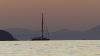 Yelkenli gemi gün batımından dönüyor.