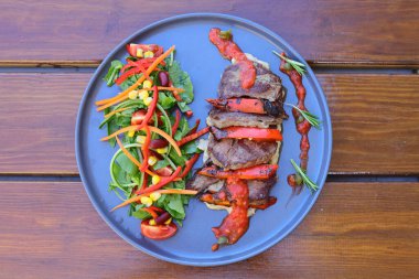 Salatalı biftek, patates kızartması ve soslu sos. Yiyecek ve sebze konsepti. Restoran ve menü teması. Kırmızı şarapla.