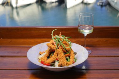 Kızarmış tavuk göğlü salata. Tavuk kanatlı taze sebze salatası. Sağlıklı yemek menüsü. Diyet yemek. Beyaz şarapla.