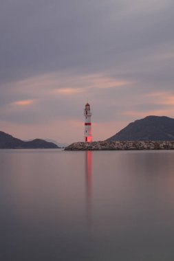 Gün batımında deniz manzarası. Sahildeki deniz feneri. Deniz feneri işaretleri ve deniz yansımaları için kullanılıyor. Yol gösterici. Deniz kenti Turgutreis ve muhteşem gün batımları.