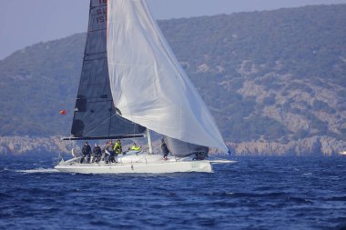 Bodrum, Hindi. 06 Aralık 2022: Yelkenliler Ege Denizi 'nin mavi sularında, ünlü tatil beldesi Bodrum' un kıyılarında rüzgarlı havada yelken açıyorlar..