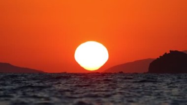 Güneş, denize batıyor. Resim akışını hızlandırmak mümkün.