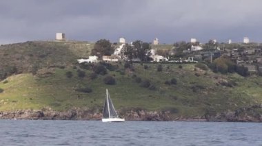 Yelkenliler rüzgarlı havada Ege Denizi 'nin mavi sularında, ünlü tatil beldesi Bodrum' un kıyılarında yelken açarlar..