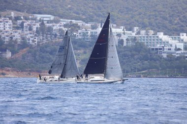 Bodrum, Hindi. 10 Mart 2023: Yelkenliler Ege Denizi 'nin mavi sularında, ünlü tatil beldesi Bodrum' un kıyılarında rüzgarlı havada yelken açıyorlar..