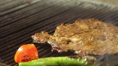 Izgarada pişmiş et parçası. Domates ve biberli..