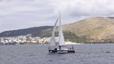 Bodrum, Hindi. 10 Mart 2023: Yelkenliler Ege Denizi 'nin mavi sularında, ünlü tatil beldesi Bodrum' un kıyılarında rüzgarlı havada yelken açıyorlar..