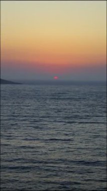Denizin üzerinde günbatımının hava görüntüsü. Sosyal medya için dikey video.