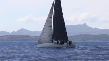 Bodrum, Hindi. 10 Mart 2023: Yelkenliler Ege Denizi 'nin mavi sularında, ünlü tatil beldesi Bodrum' un kıyılarında rüzgarlı havada yelken açıyorlar..