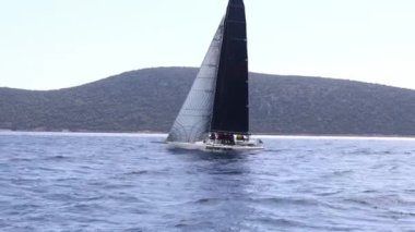 Bodrum, Hindi. 10 Mart 2023: Yelkenliler Ege Denizi 'nin mavi sularında, ünlü tatil beldesi Bodrum' un kıyılarında rüzgarlı havada yelken açıyorlar..