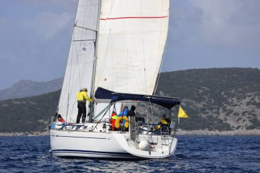 Bodrum, Hindi. 12 Mart 2023: Yelkenliler Ege Denizi 'nin mavi sularında, ünlü tatil beldesi Bodrum' un kıyılarında rüzgarlı havada yelken açıyorlar..